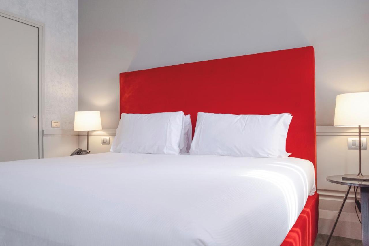 ホテル パラッツォ コーナリア ミラノ エクステリア 写真 A bed with a red headboard